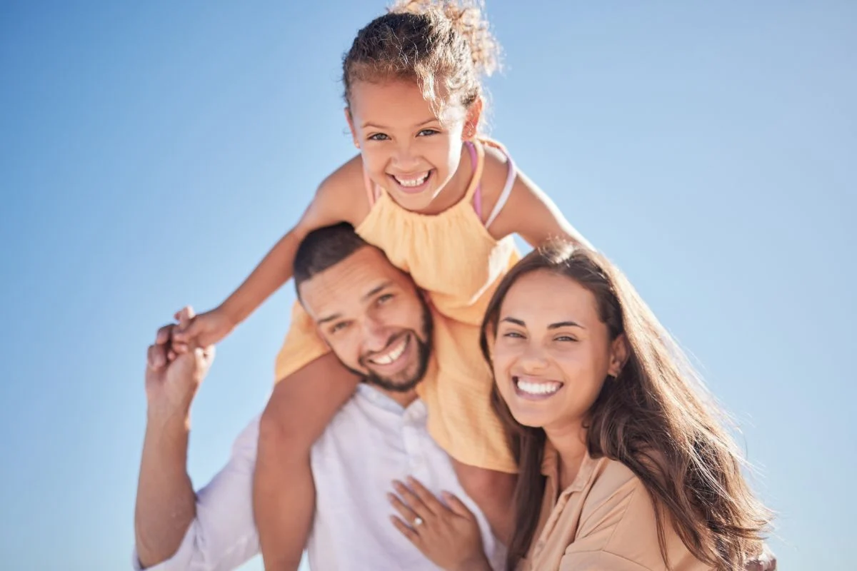 Family smiling outdoors showing improved health and quality of life with Elaria Allergy & Integrative Health support.